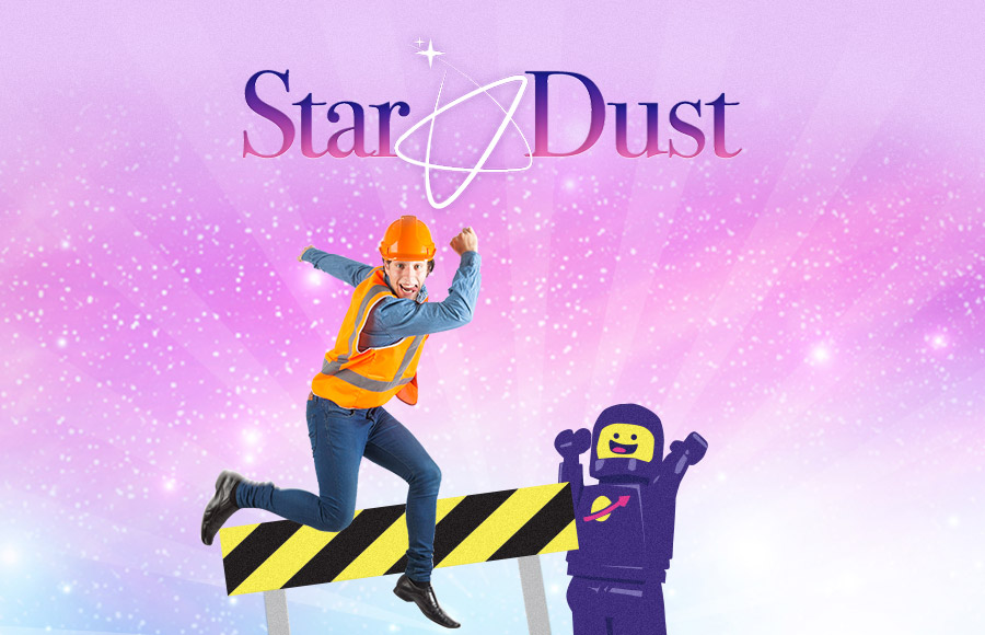 A man entertainer dressed as a construction worker in an orange hard hat and safety vest is shown leaping over a striped yellow-and-black barrier in a glittery graphic for Star Dust Kids Entertainment. A large, purple, cartoon Lego astronaut is positioned to the right, and smiling children are visible in the foreground